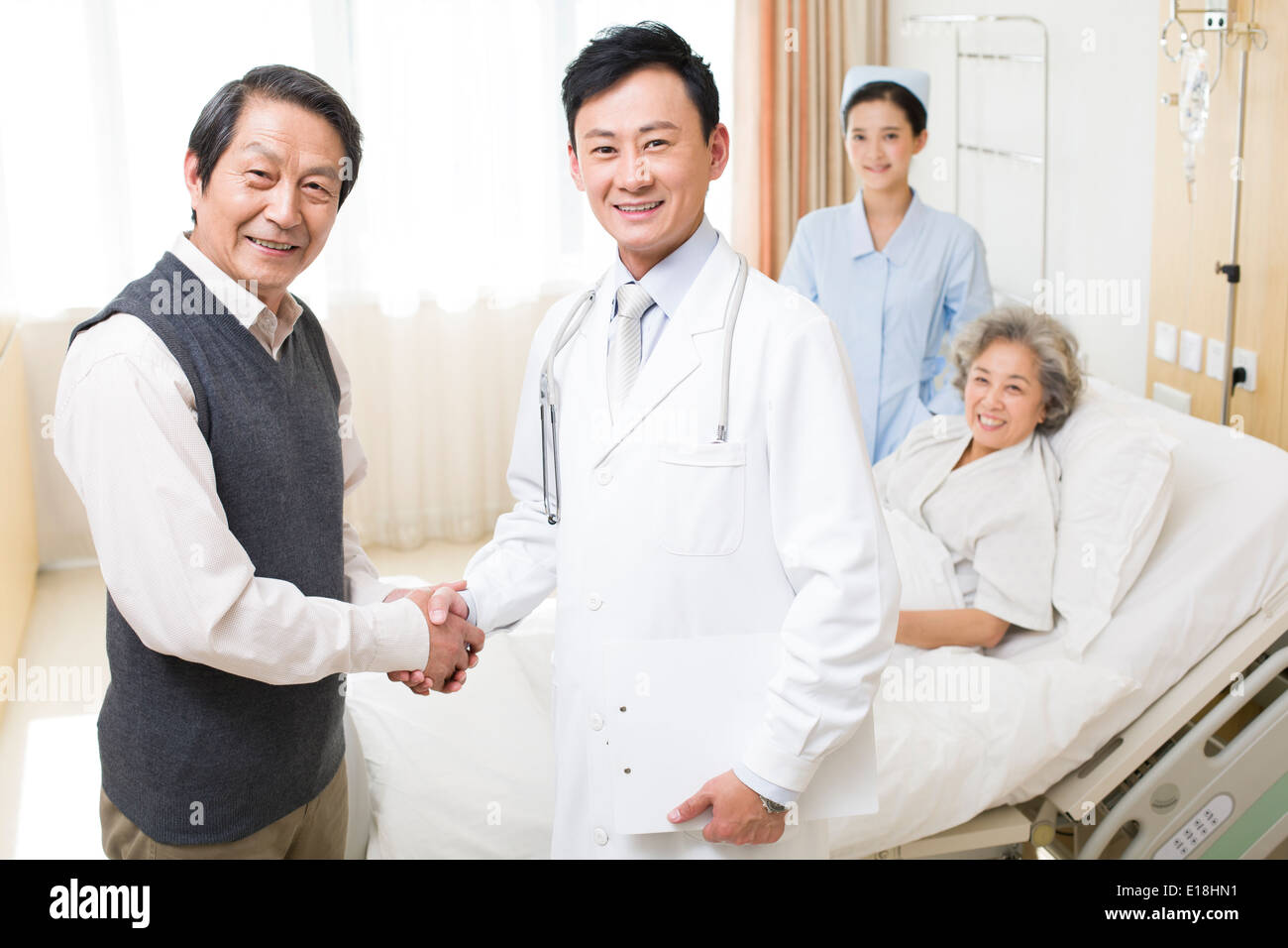 Älteres paar Händeschütteln mit Arzt im Krankenhaus Stockfoto