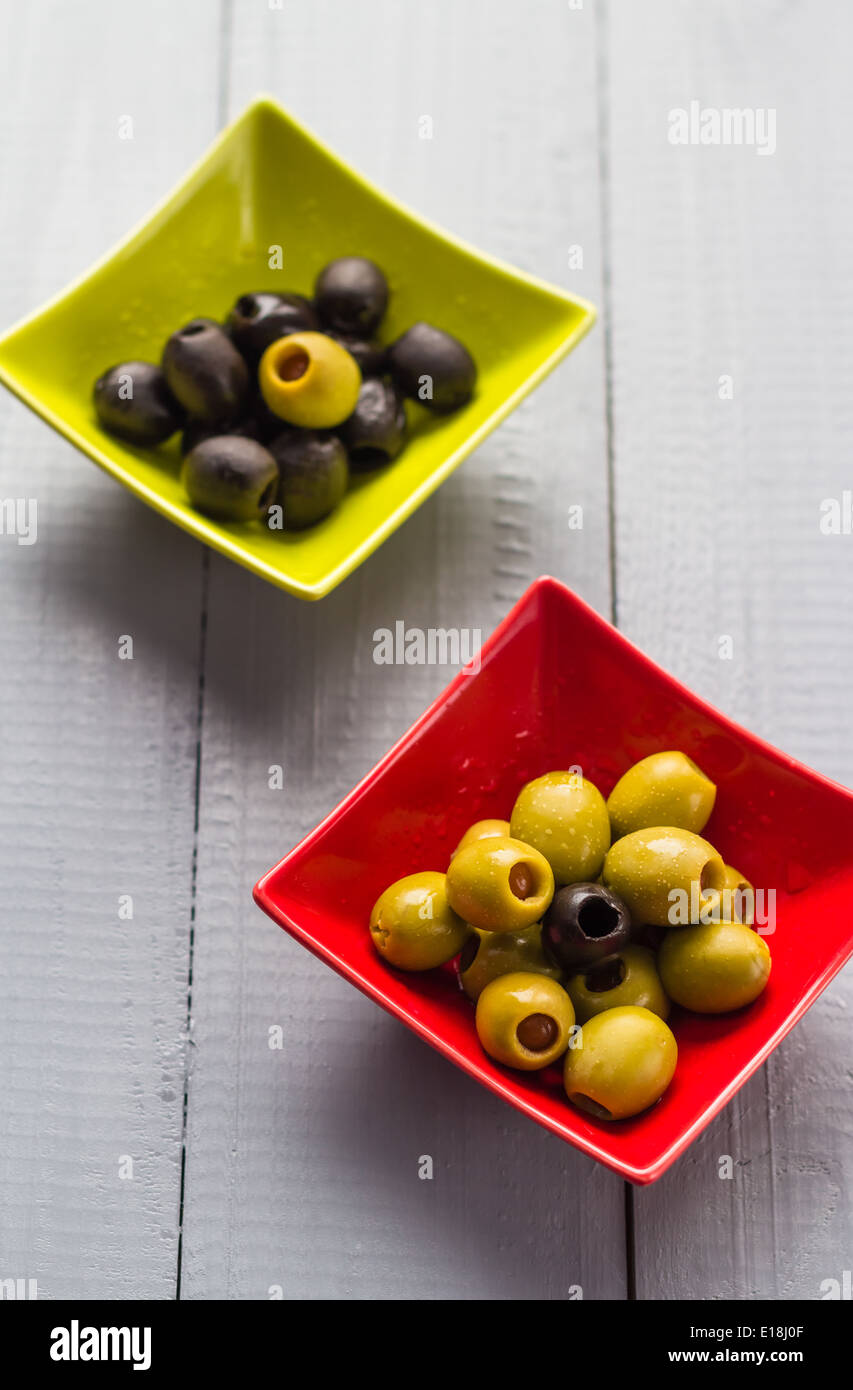 Bunte Obst Oliven in Schalen auf Holztisch Stockfoto