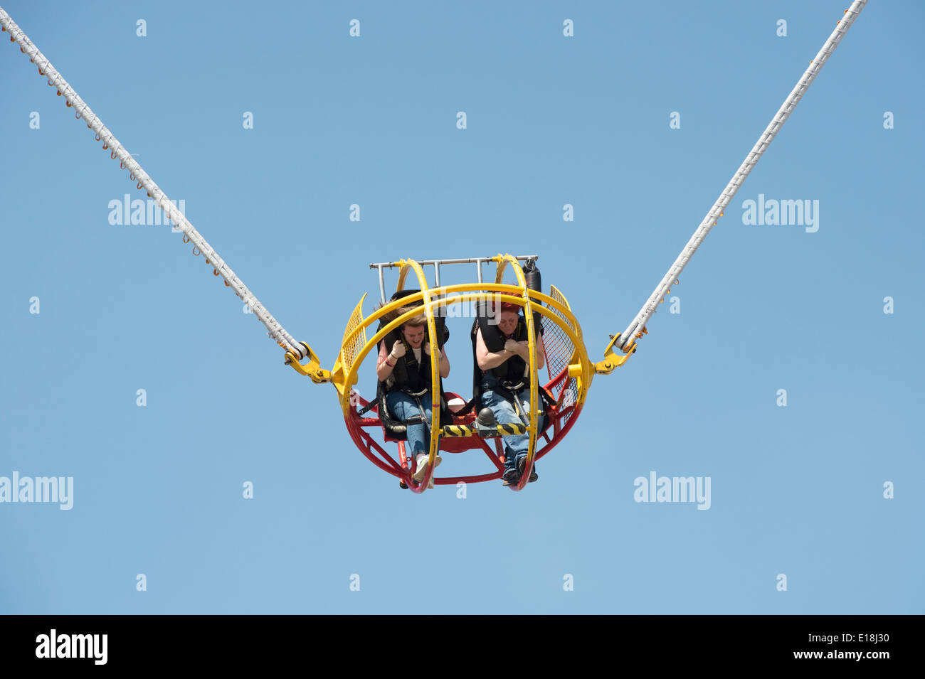 Zwei Frauen auf einen umgekehrten Bungee-Start Festplatz fahren Stockfoto
