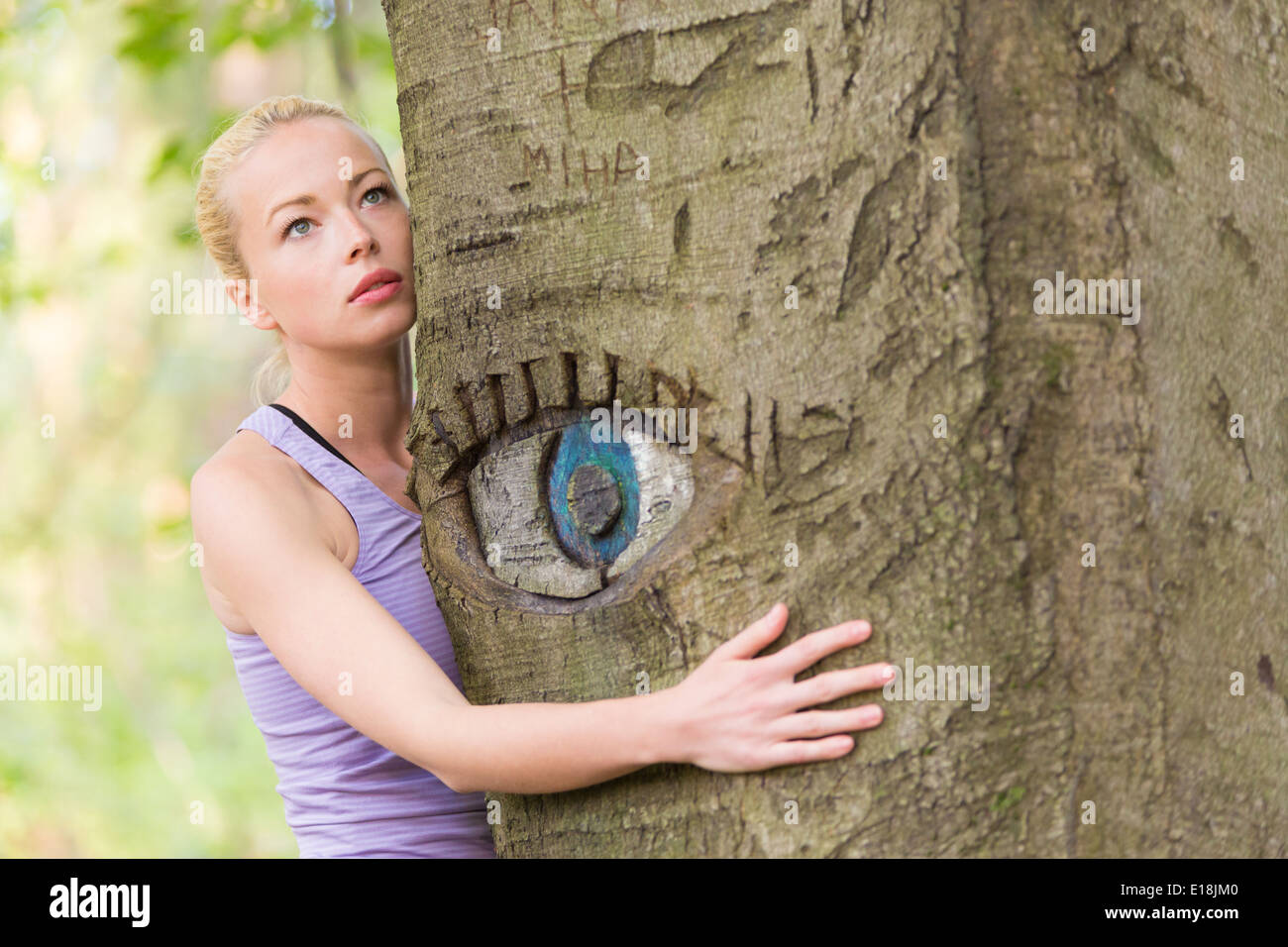 Junge Frau umarmt einen Baum. Stockfoto