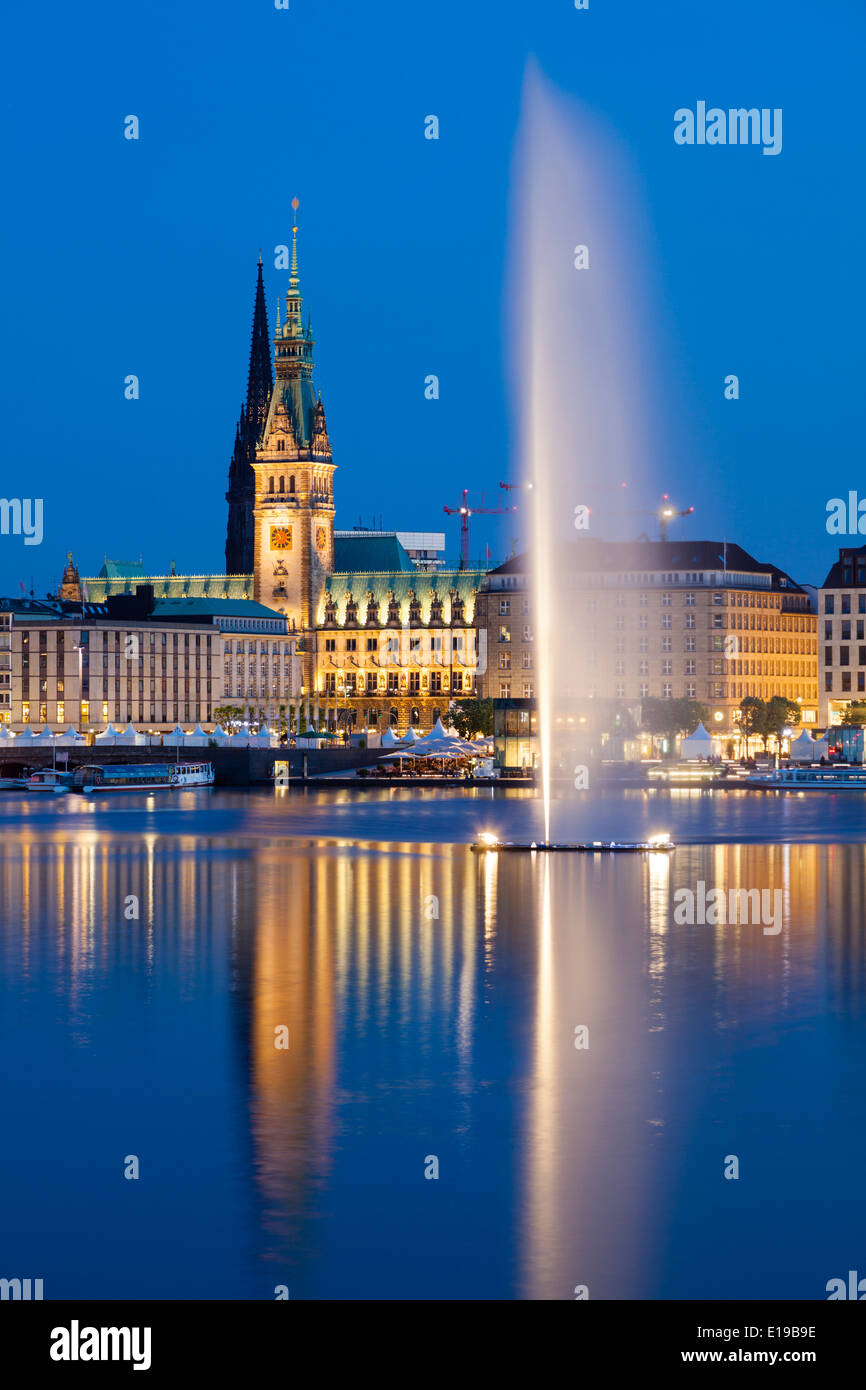 Die berühmten Binnenalster Brunnen in Hamburg, Deutschland in der Nacht mit dem Rathaus im Hintergrund Stockfoto