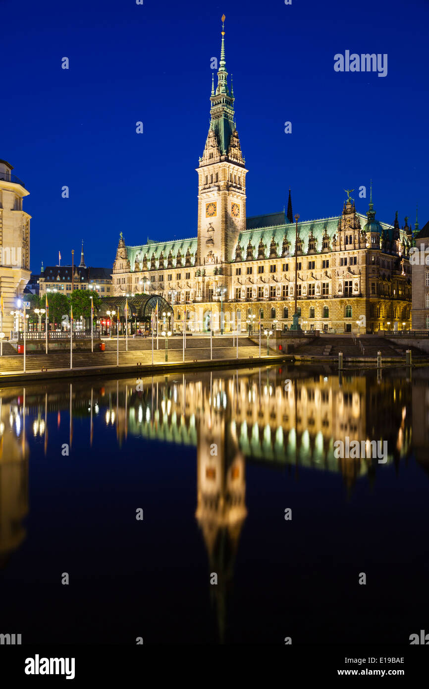 Das berühmte Rathaus in Hamburg, Deutschland in der Nacht mit Reflexion in einem Kanal Stockfoto