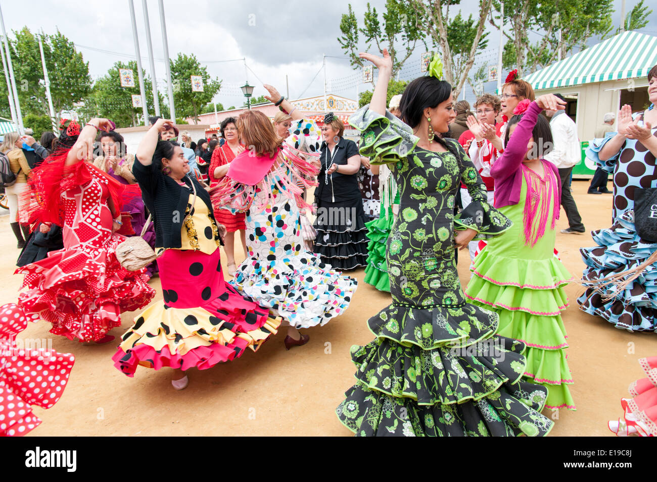 Frauen in bunten Flamenco-Kleider tanzen auf der Sevilla April Messe, Spanien Stockfoto