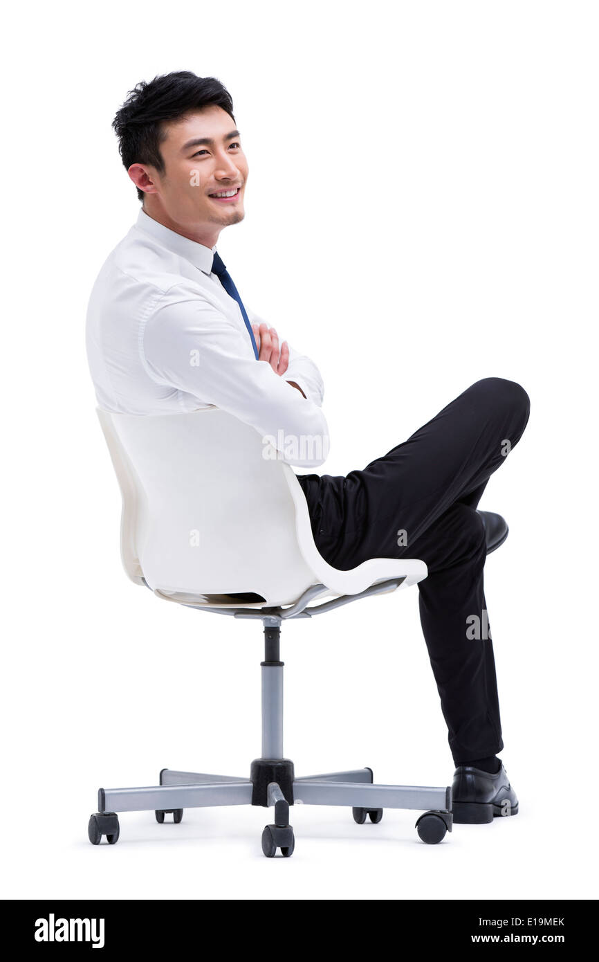 Zuversichtlich junger Geschäftsmann auf Stuhl sitzend Stockfoto
