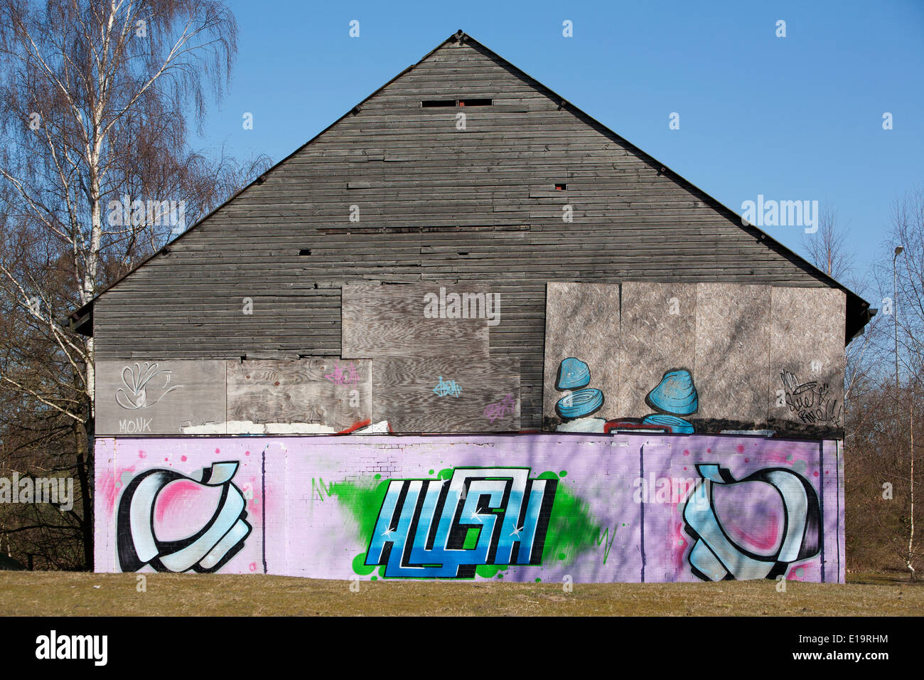 Graffiti (Straßenkunst) markieren Sie auf der Seite ein Backstein und Holz Scheune Struktur. Stockfoto