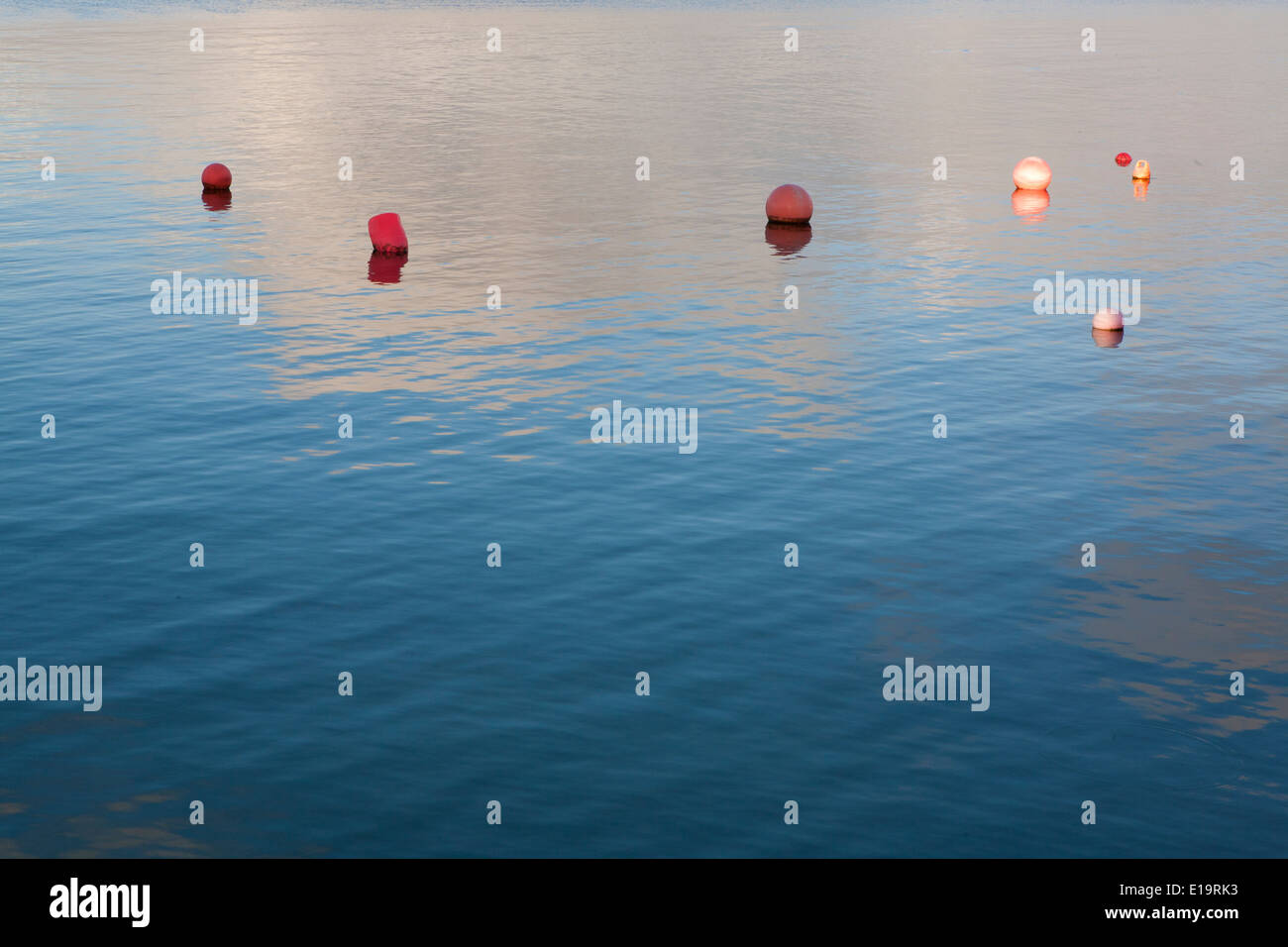 Bewölkter Himmel spiegelt sich im Meer schwimmenden Bojen. Stockfoto