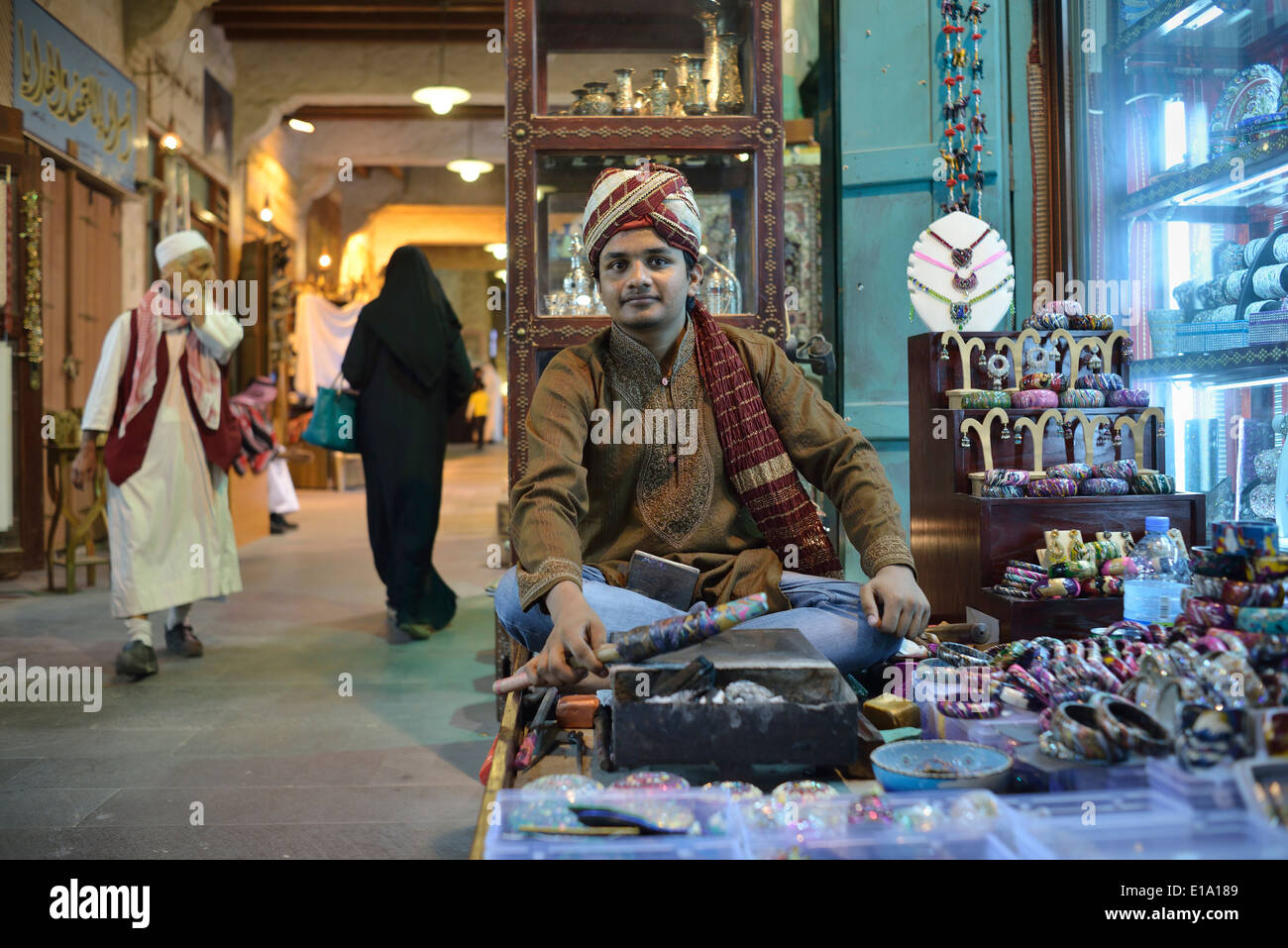Doha. Katar. Souq Waqif. Indischer Mann machen Armbänder. Stockfoto