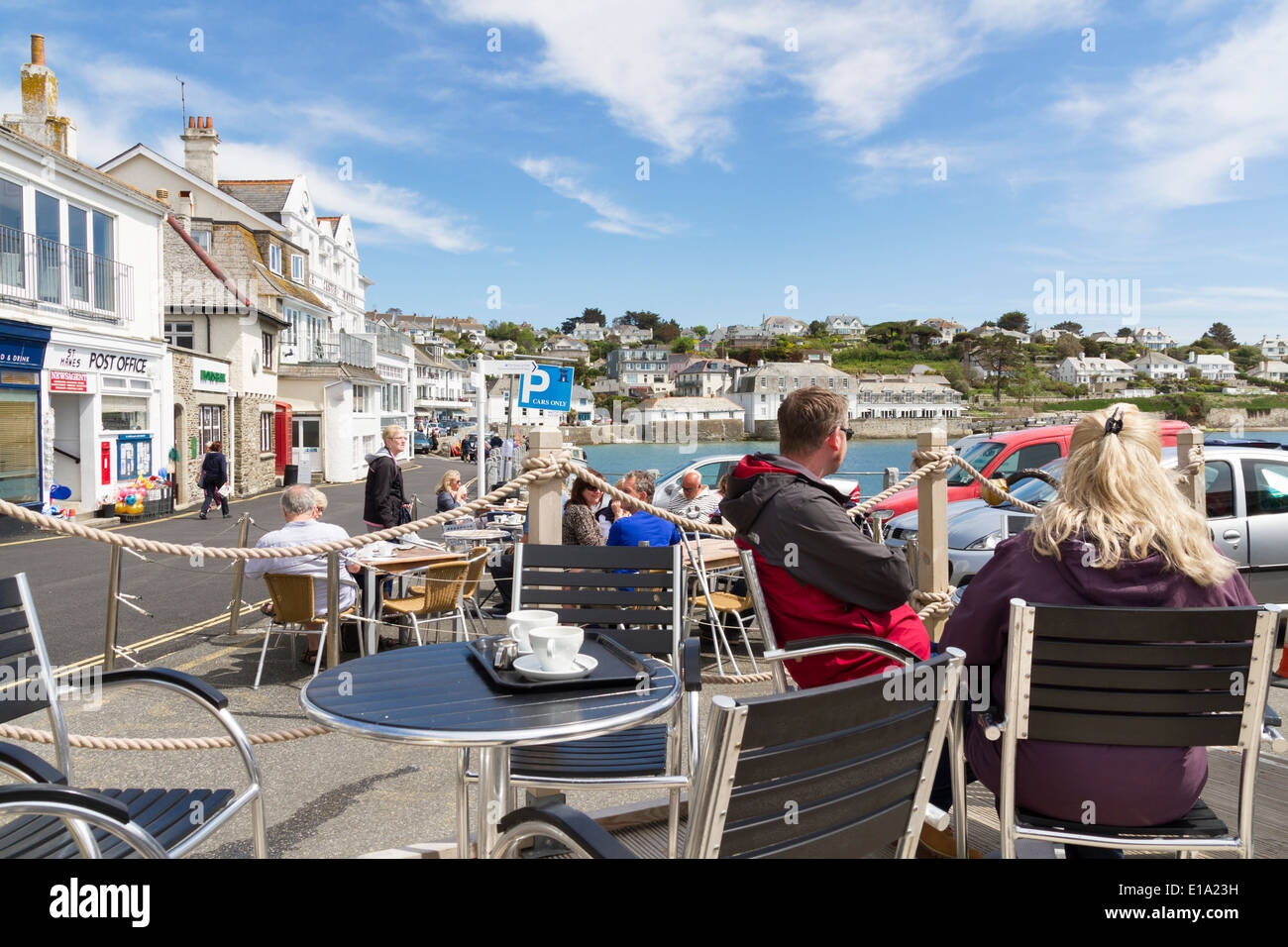 Touristen, Essen und trinken in den Sitzbereich im Freien in einem Café in St. Mawes Cornwall Stockfoto