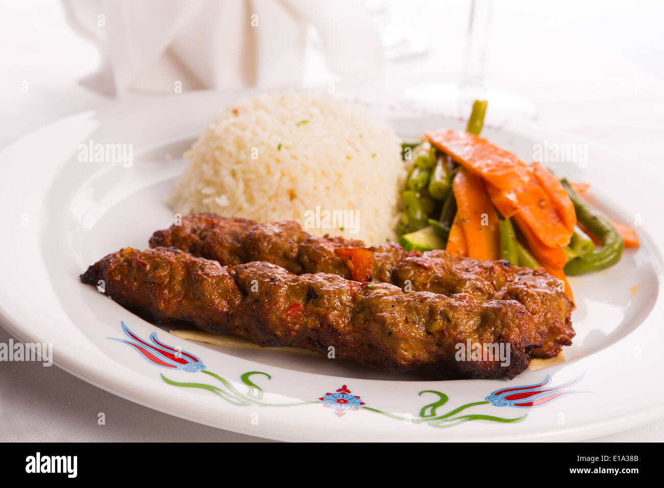 Türkische Adana Kebap Reis-Pilaw mit Gemüse auf einem Teller serviert Stockfoto