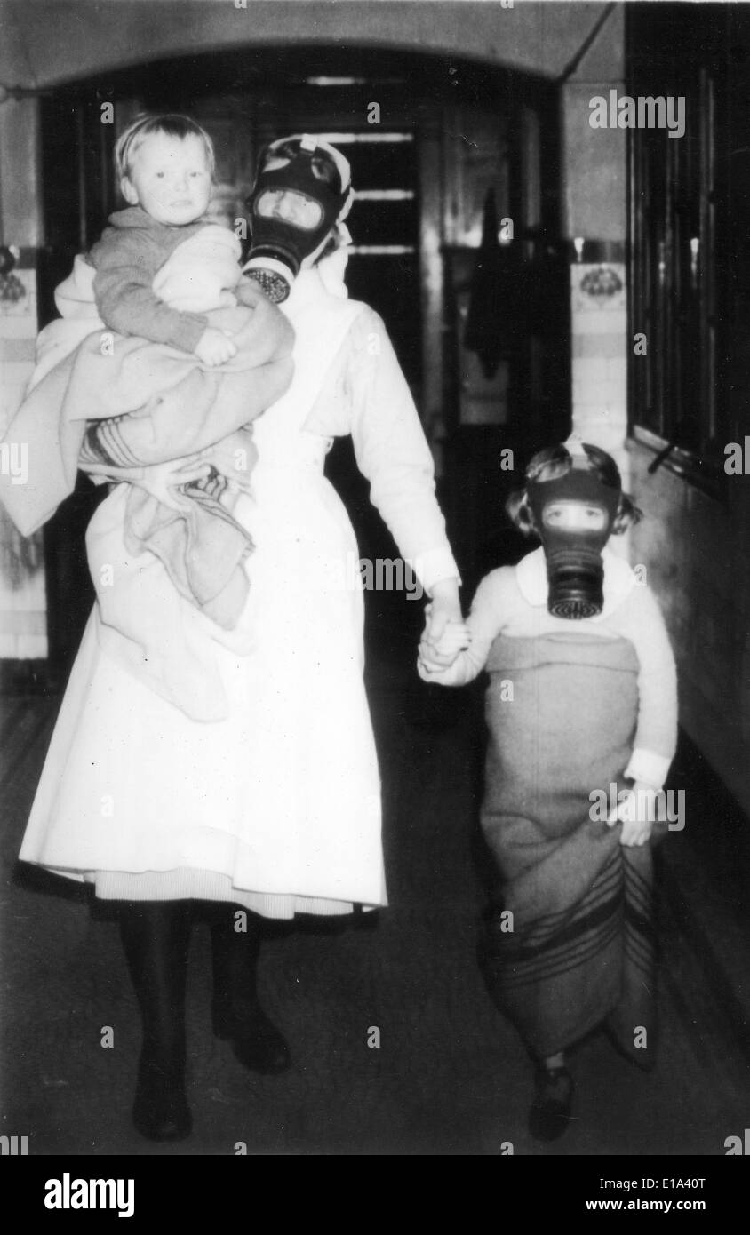 BRITISH HOME FRONT WW2 A Krankenschwester führt ein Kind und Baby in Armen ins Tierheim bei einem mock Gasangriff. Stockfoto