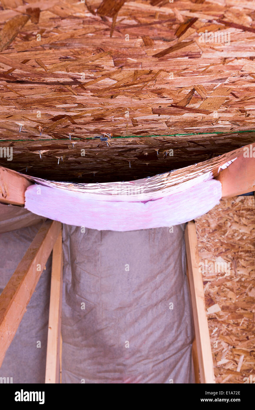 Isolierung des Dachbodens mit Fiberglas kalt Barriere und reflektierende Hitze Barriere als Trennwand zwischen den Dachboden-Balken verwendet, ist die Arbeit auf Stockfoto