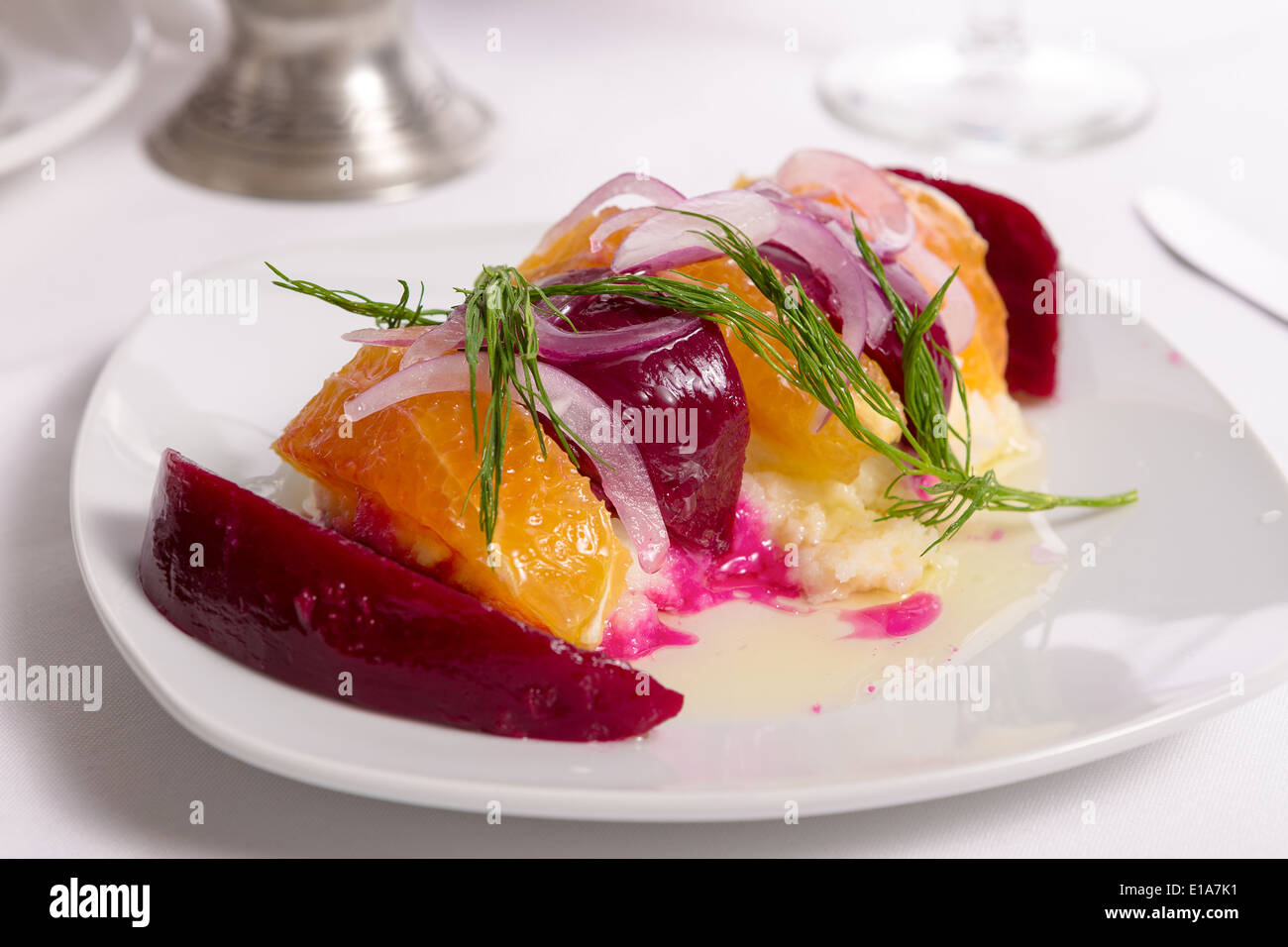 Gespannte Joghurt Labneh Zitrus-Salat mit eingelegten Rüben und geschälte Orangen garniert mit Zwiebeln und Dill serviert mit Öl Stockfoto