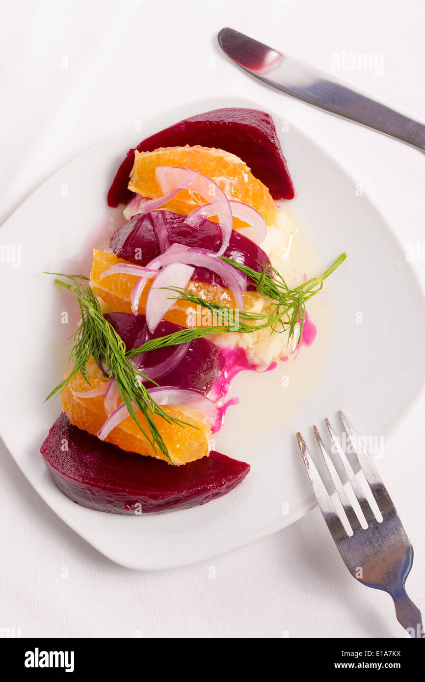 Gespannte Joghurt Labneh Zitrus-Salat mit eingelegten Rüben und geschälte Orangen garniert mit Zwiebeln und Dill serviert mit Öl Stockfoto