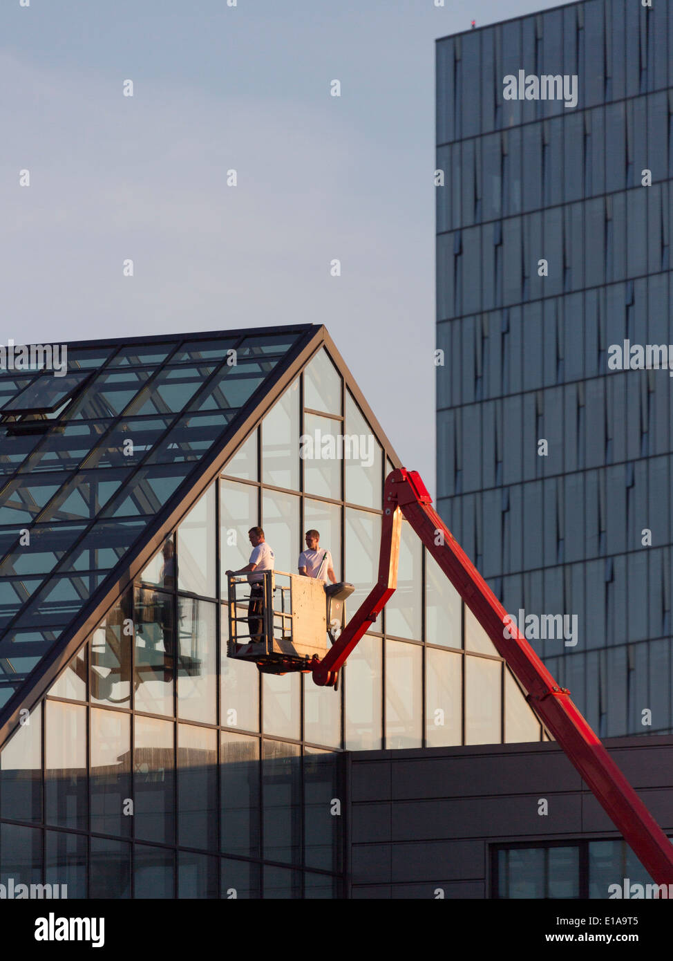 Arbeiten an der Außenseite eines Gebäude aus Glas, Reykjavik, Island Stockfoto