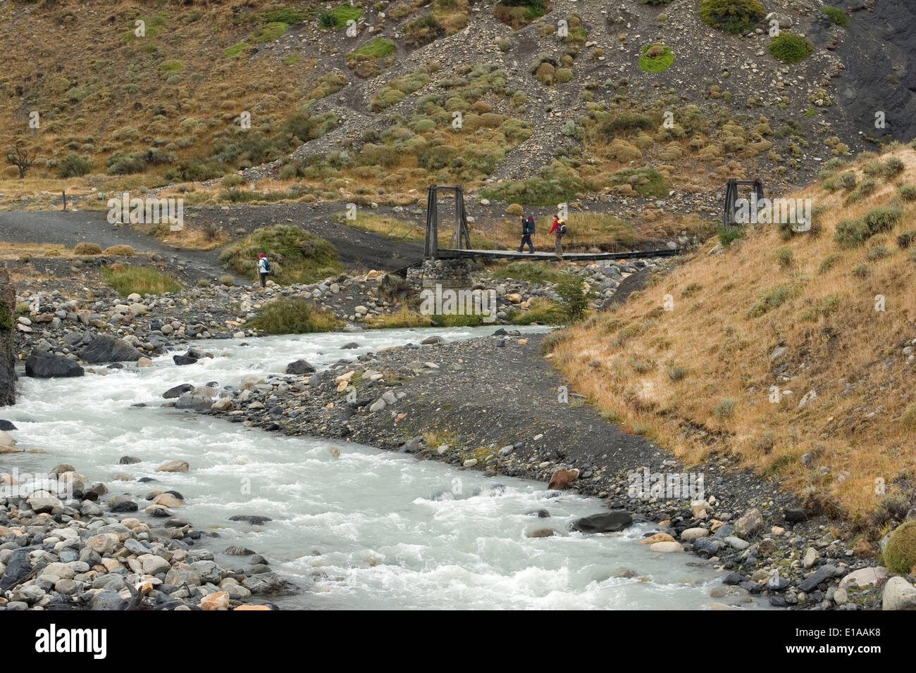 Wanderer durchqueren Brücke über Fluss Ascencio, Torres del Paine Nationalpark, Patagonien, Chile Stockfoto