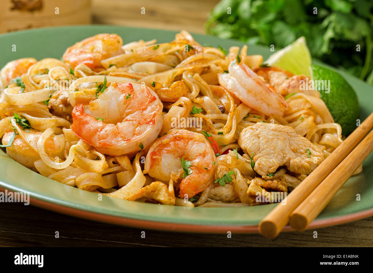 Ein Teller mit würzigen pad Thai mit Huhn und Garnelen mit Stäbchen. Stockfoto