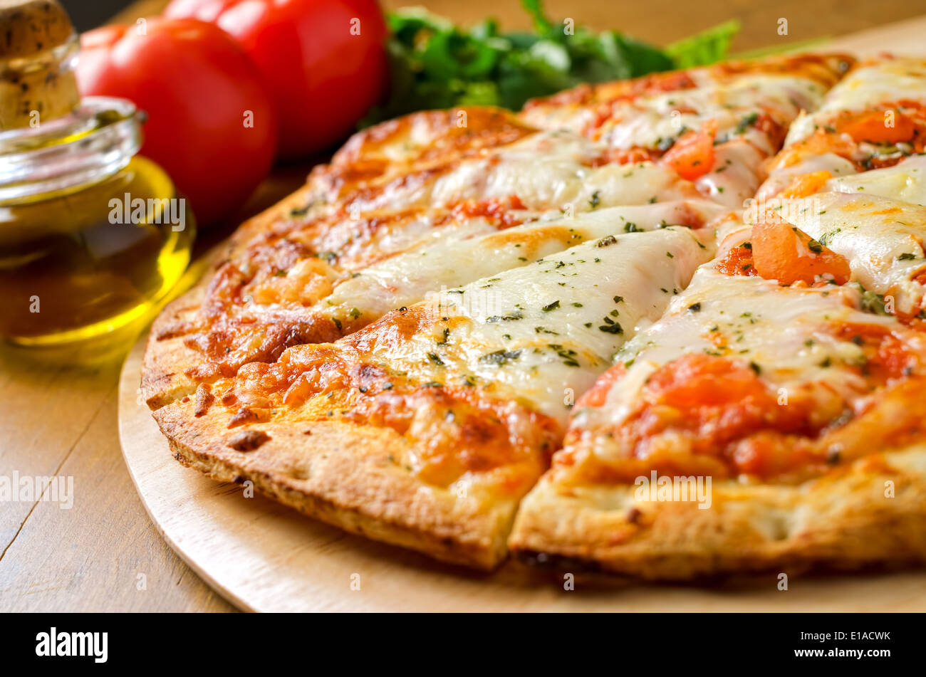 Eine frisch gebackene Pizza Margherita mit Tomaten, Olivenöl, frischem Basilikum und Mozzarella-Käse. Stockfoto