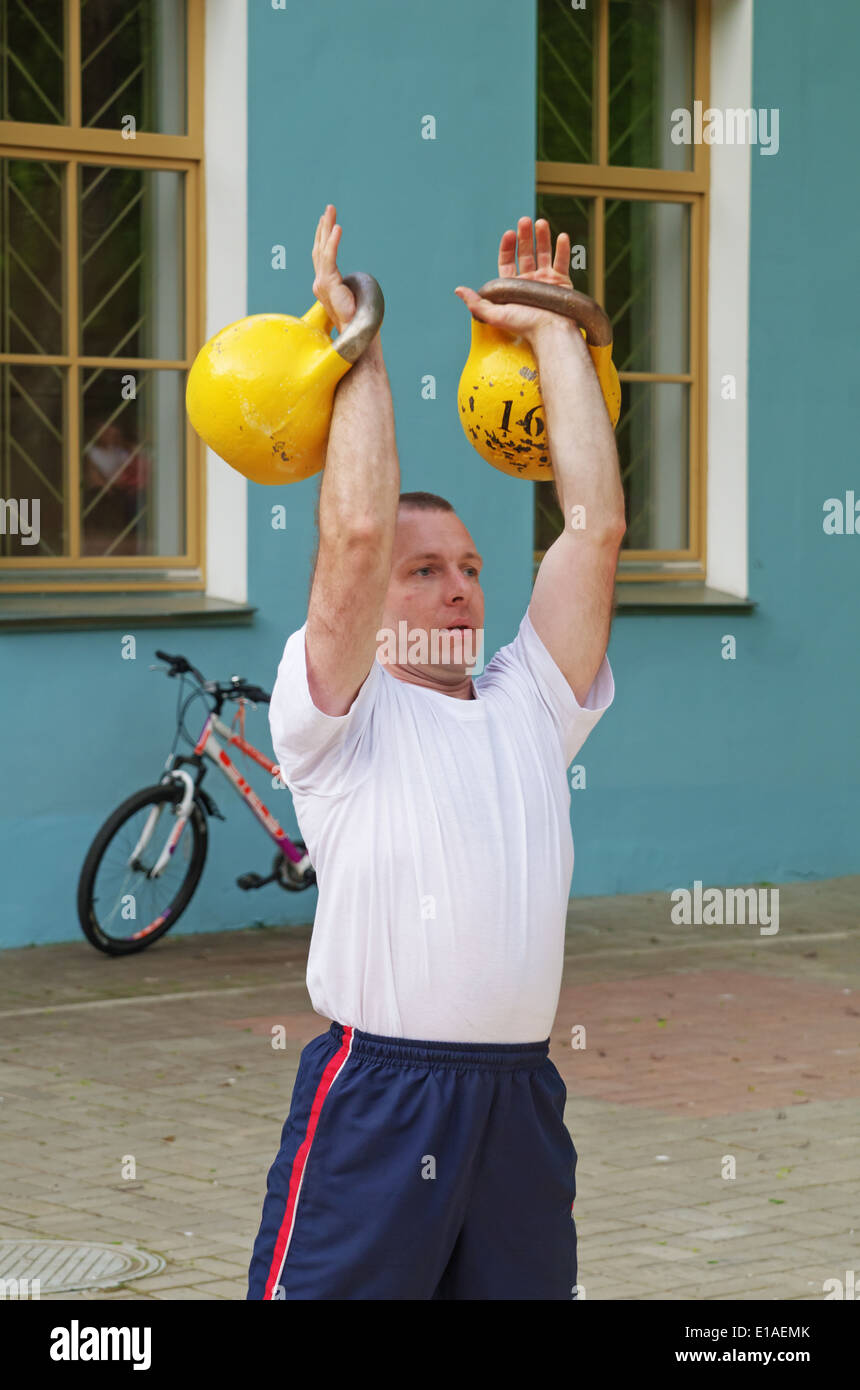 Fitness-Mann mit Kettlebell training. Leistung für die Gäste des Museums. Stockfoto