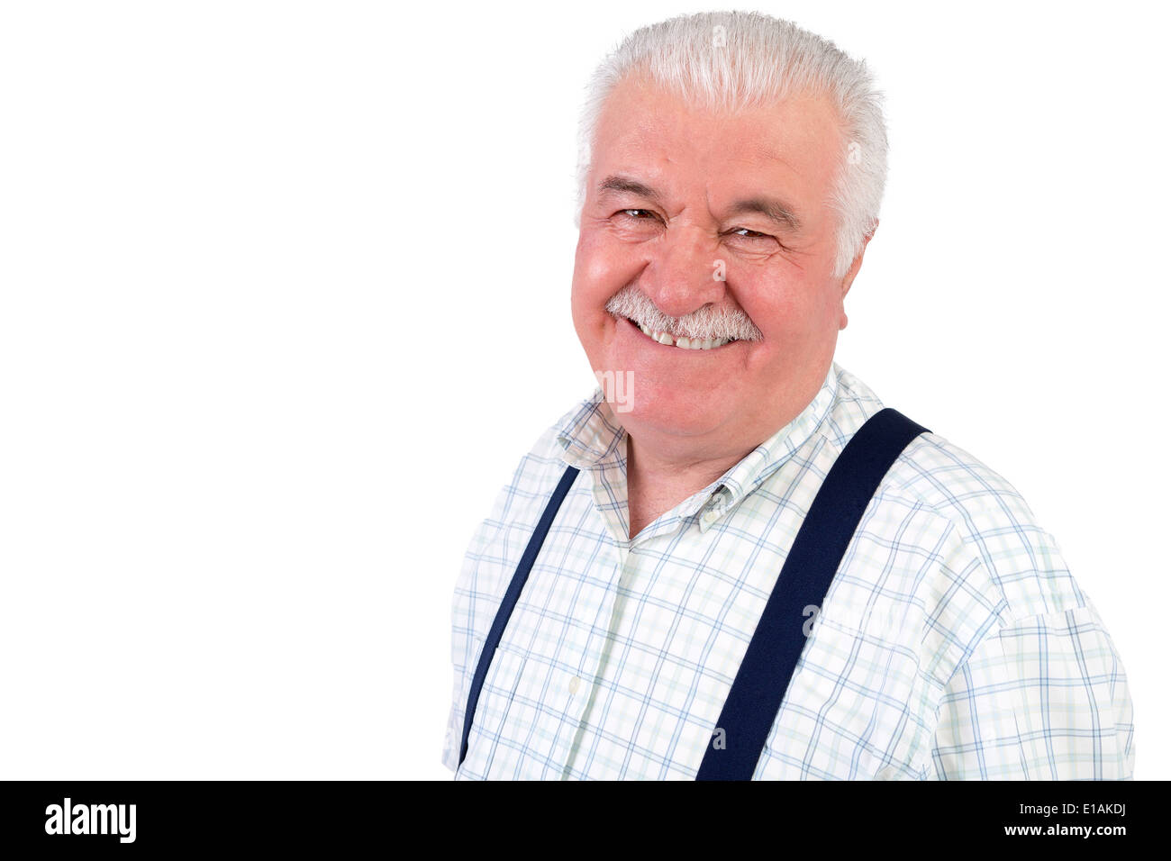Jovial senior grauhaarige Mann trägt Hosenträger mit einem strahlenden Lächeln in die Kamera schaut lächelnd, isoliert auf weiss mit copyspac Stockfoto