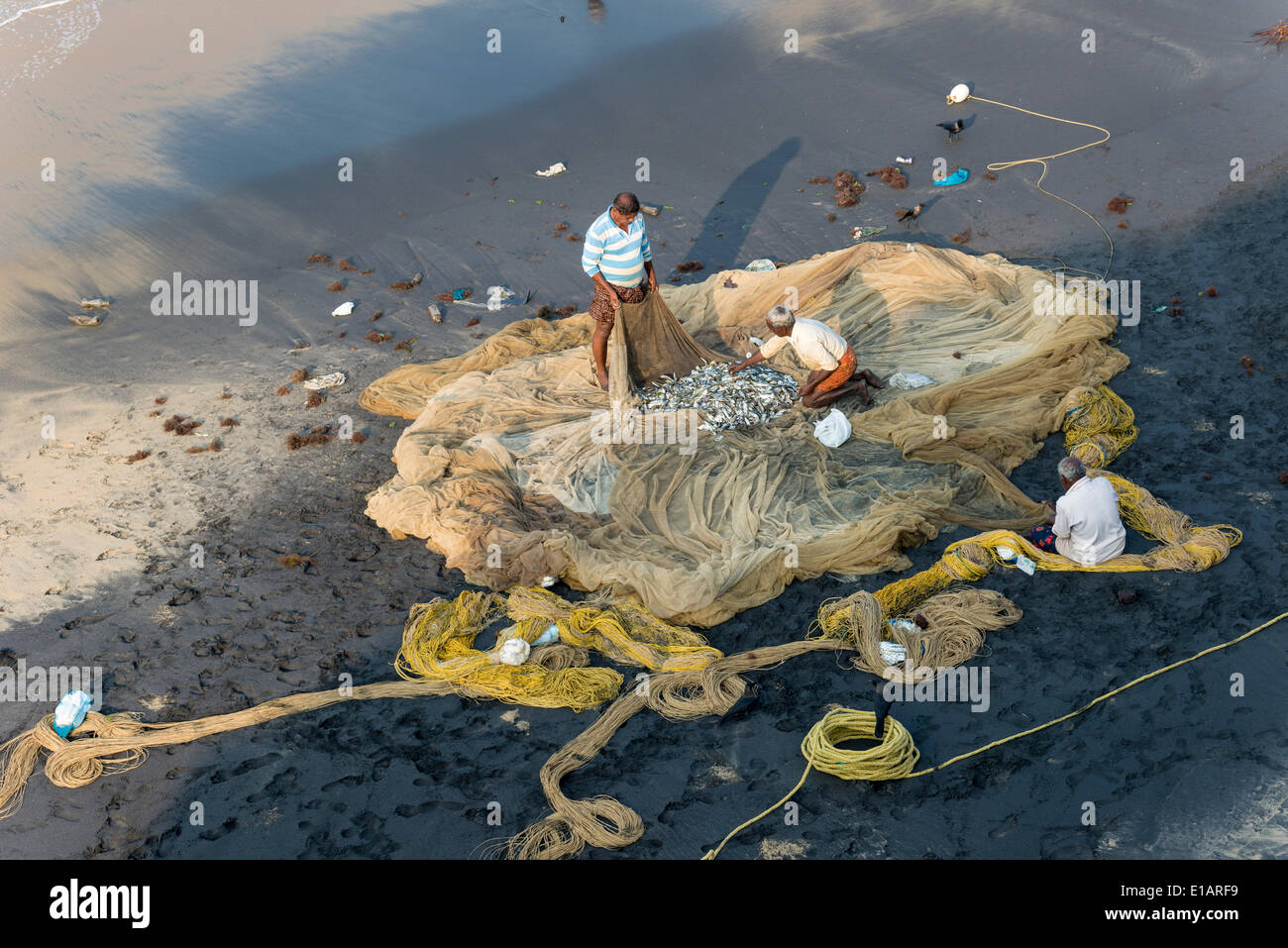 Fischer Inspektion Fischernetze am Strand Varkala, Kerala, Indien Stockfoto