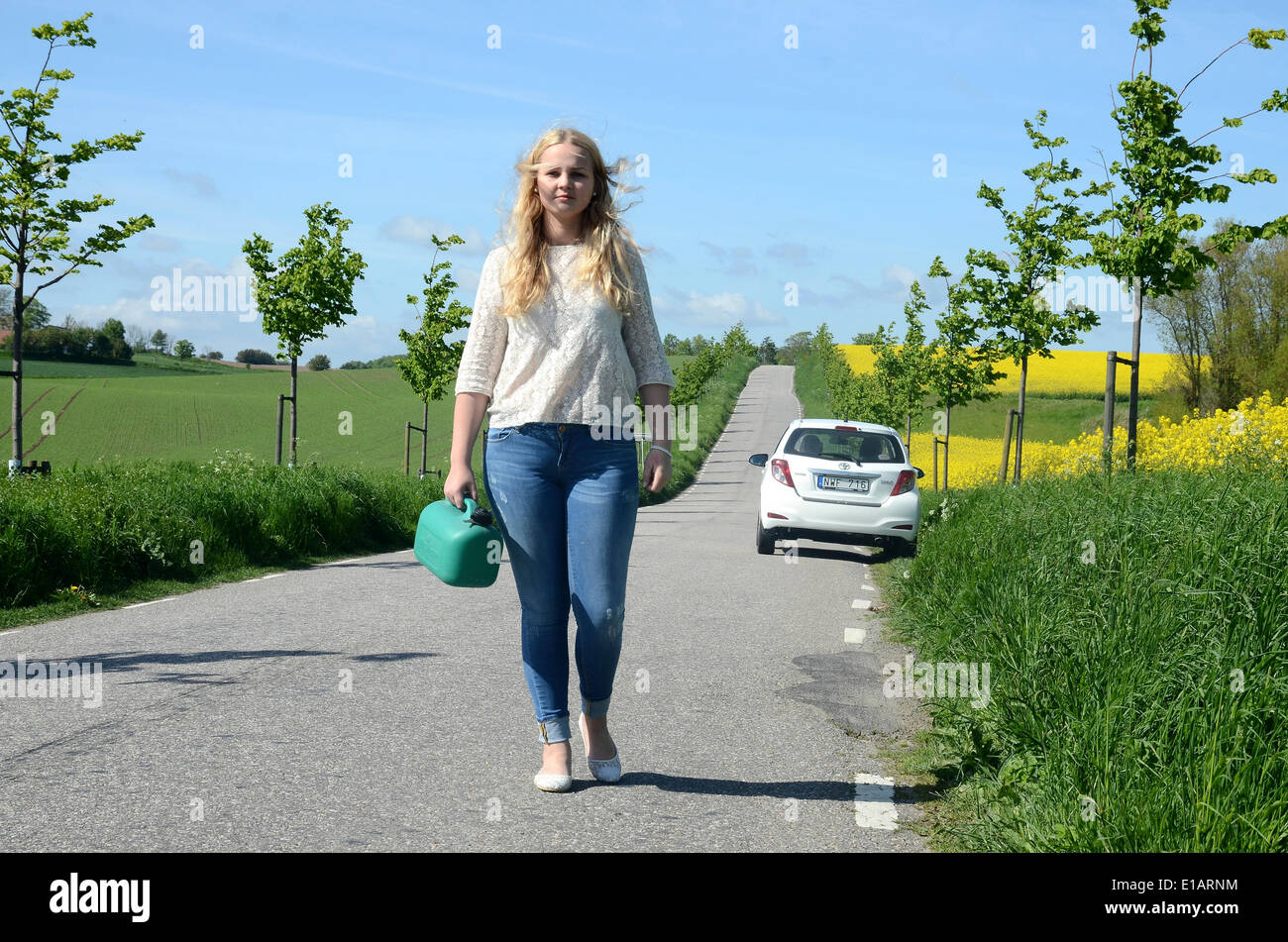 Frau zu Fuß entfernt von ihrem Auto tragen eine Benzin kann, Skåne, Schweden Stockfoto