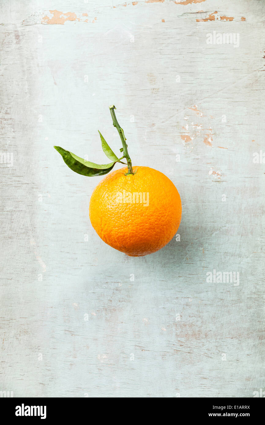 Reife Orange mit Blatt auf strukturierten Hintergrund Stockfoto