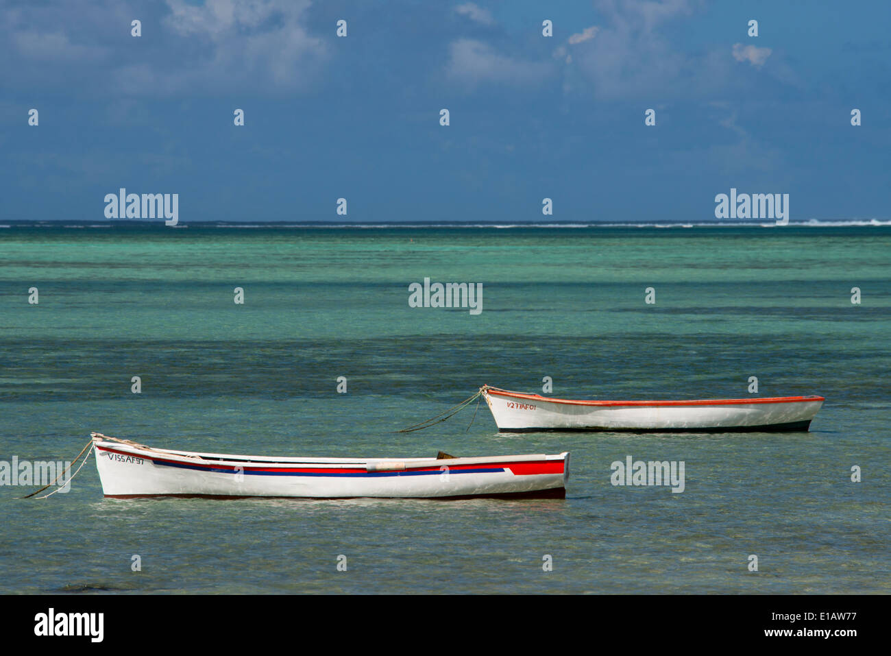 Alte hölzerne Boote vertäut innerhalb des Riffs auf Mauritius. Im Indischen Ozean Stockfoto