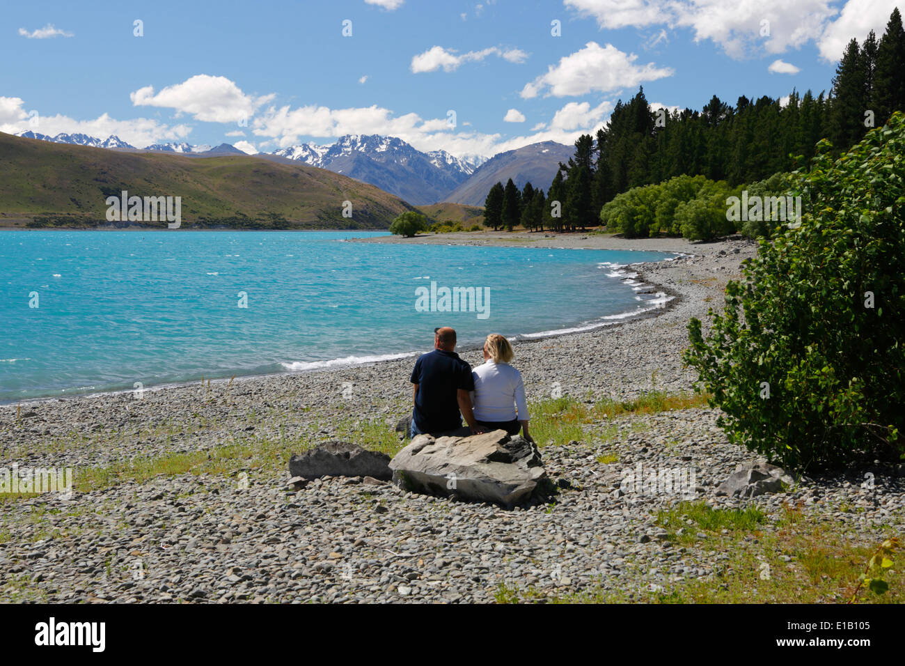 Paar sitzt neben See, Lake Tekapo, Canterbury Region, Südinsel, Neuseeland, Südpazifik Stockfoto