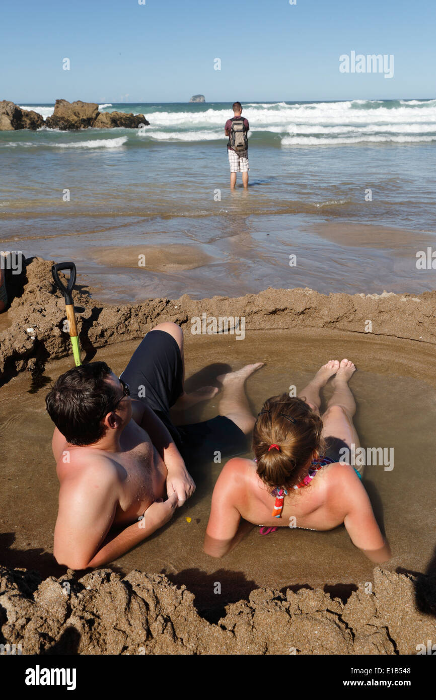 Touristen, die in heißen Quellen entspannen am Strand gegraben Stockfoto