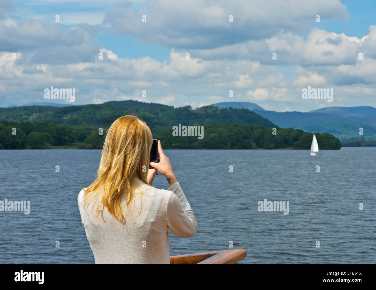 Junge Frau auf Passagier "Dampfer", mit dem Fotografieren auf Smartphone, Lake Windermere, Lake District, Cumbria, England UK Stockfoto