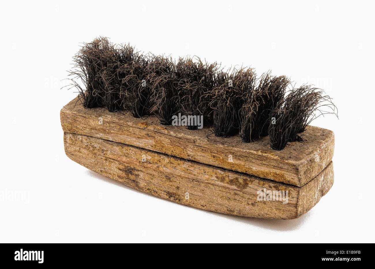 Bronzebürste mit Holzgriff, für die Reinigung von Wildleder vor weißem Hintergrund fotografiert Stockfoto