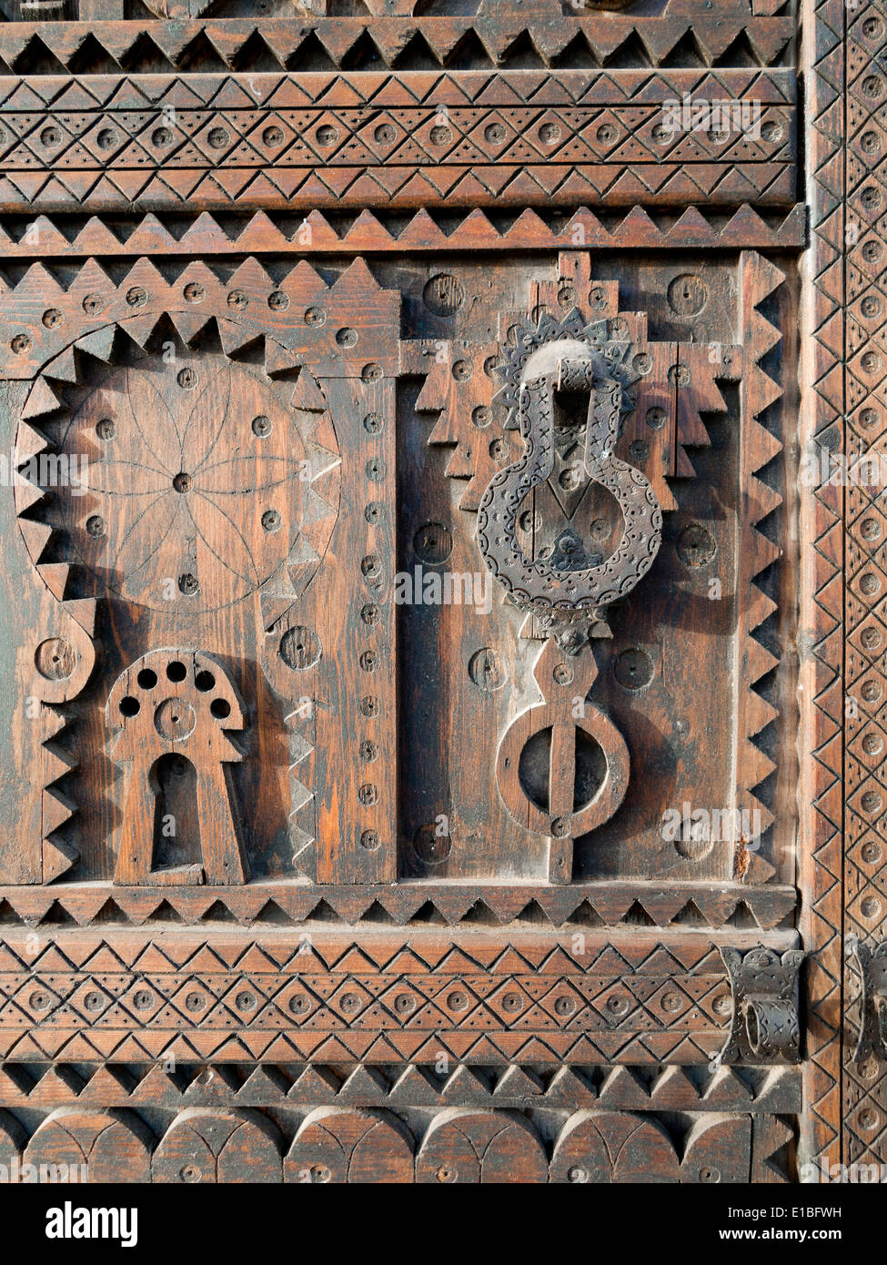 Nahaufnahme Detail geschnitzten Holz auf einem marokkanischen Tür mit schwarzem Eisen Klopfer und behandeln Stockfoto