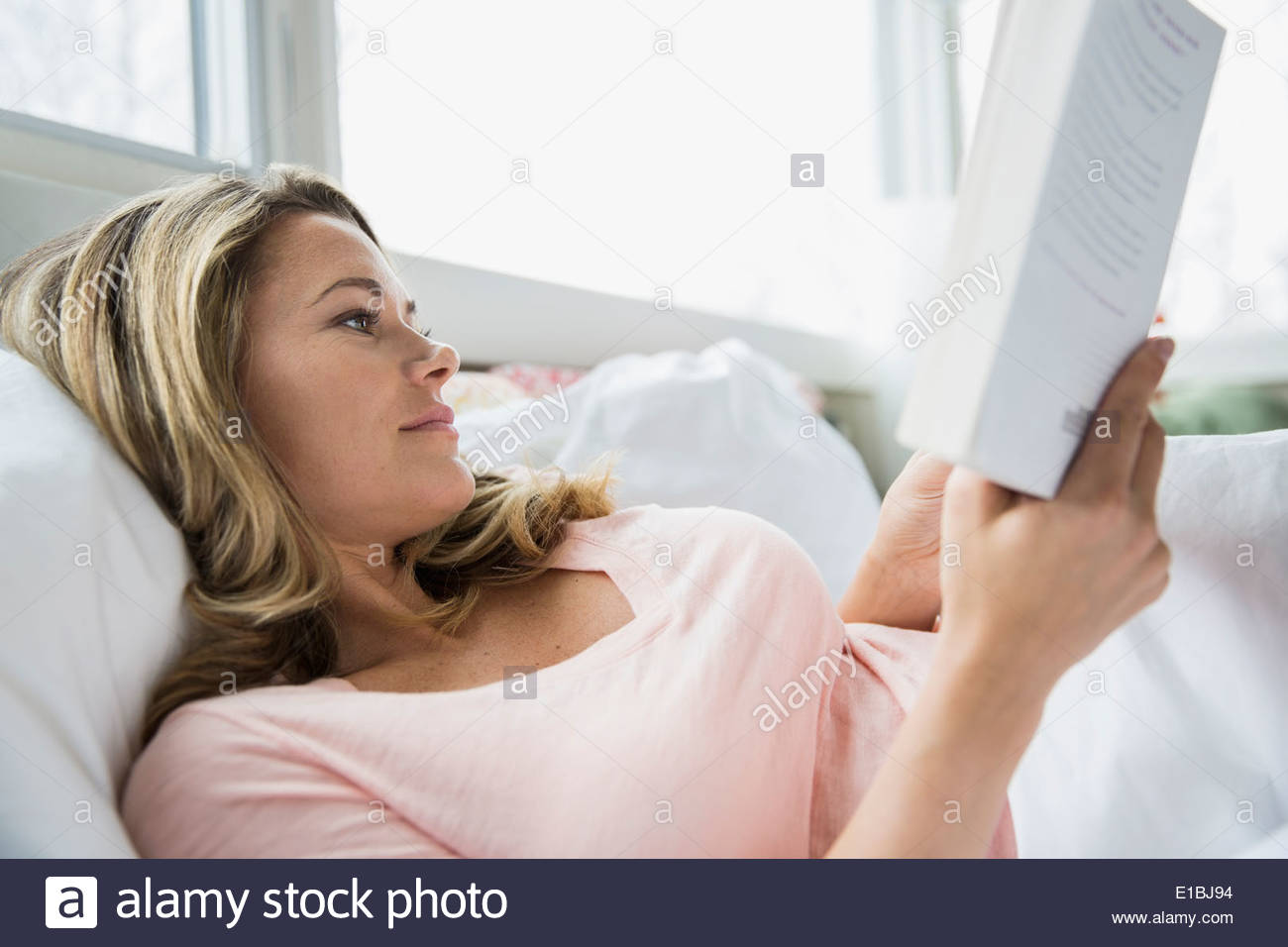 Lesebuch der Frau im Bett Stockfoto