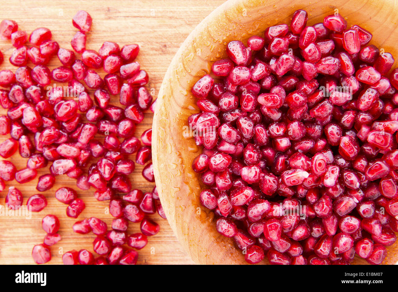 Holzschale mit gefüllt, gereinigt und vorbereitet, saftige Reife Granatapfelkerne oder Arils reich an vItamin K und Antioxidantien Stockfoto