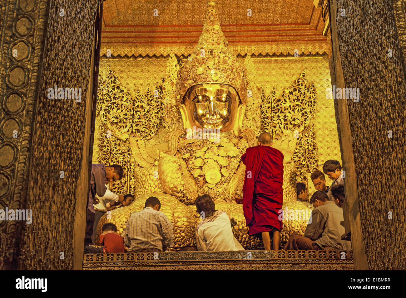Burmesische Gläubigen beten Buddha Statue einfügen Blattgold Blütenblätter in Mahamuni Pagode, Mandalay, Myanmar. Stockfoto