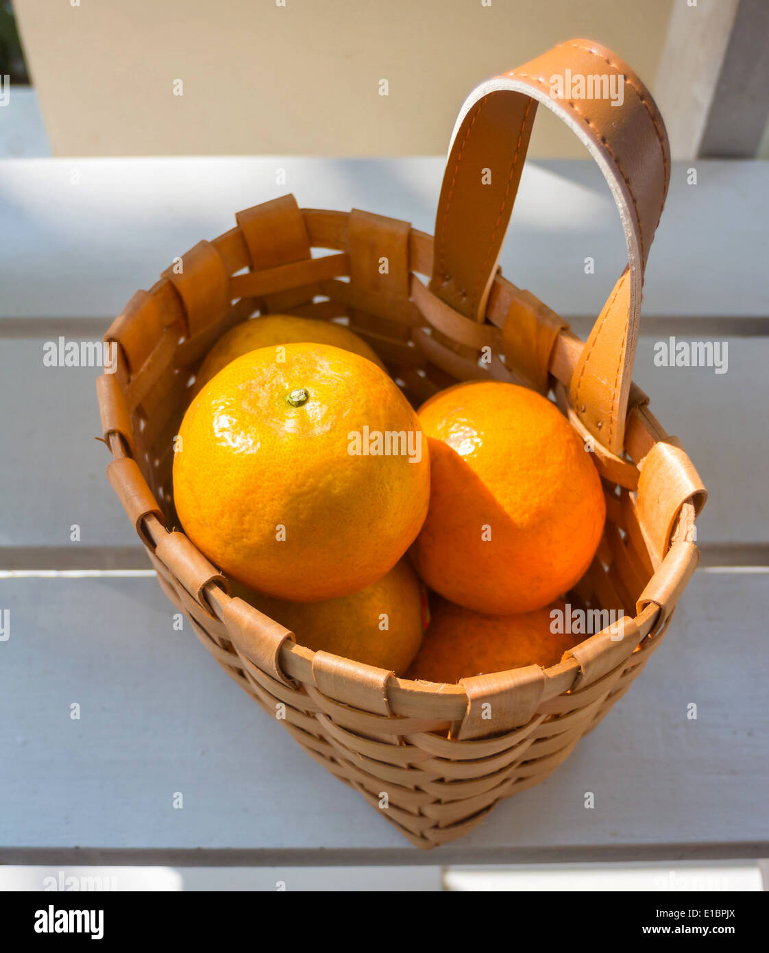 Orangen in den Korb auf weißen Stuhl. Stockfoto