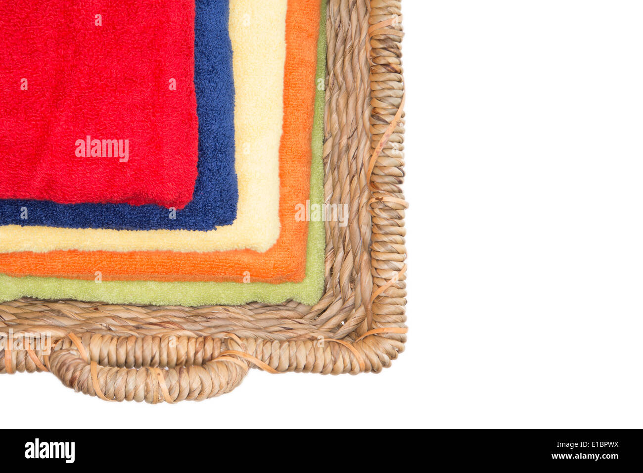 Saubere bunte gewaschenen Handtücher in einem Weidenkorb ordentlich gefaltet und gestapelt angesehen von oben geben eine mehrfarbige Muster von dim Stockfoto