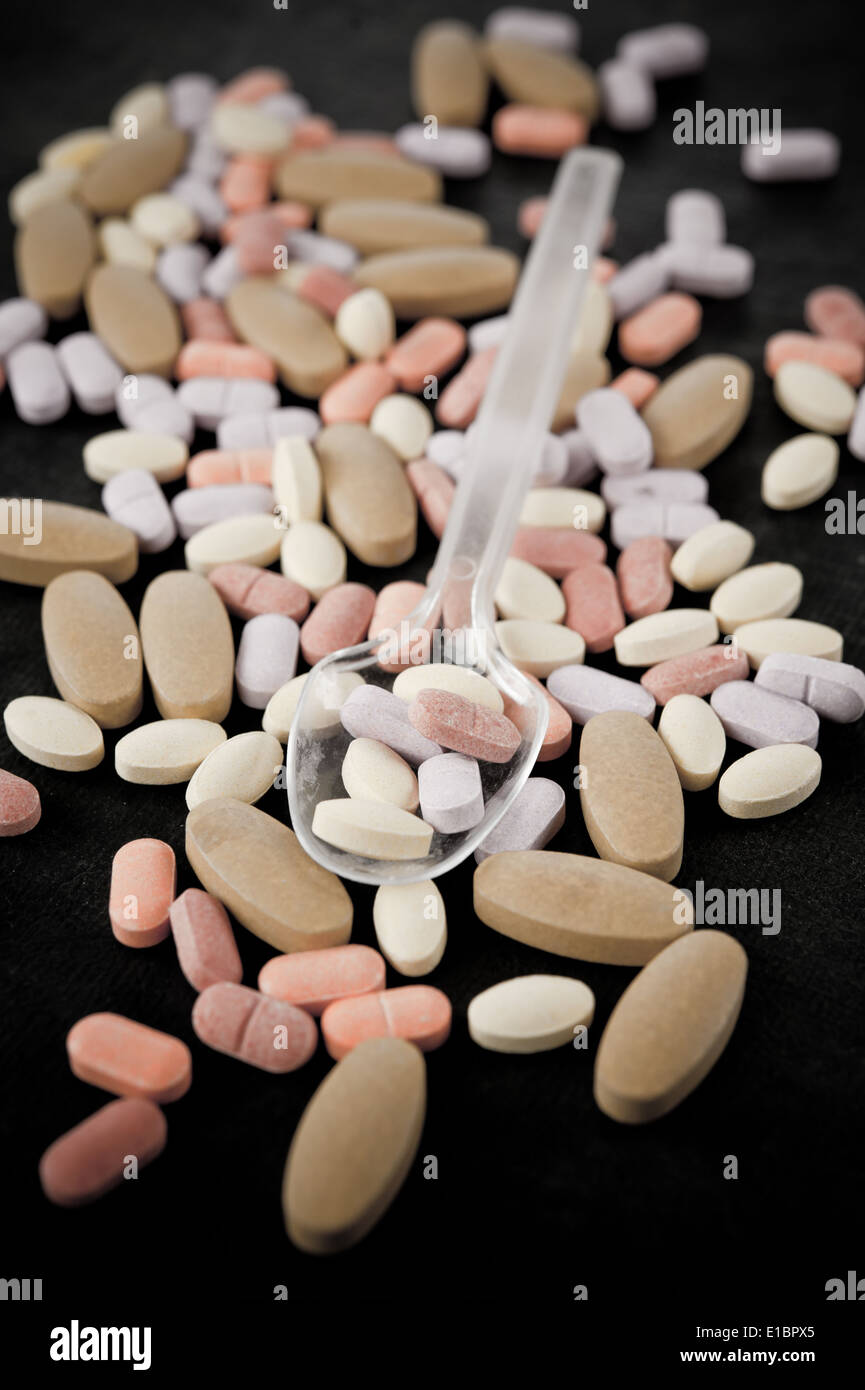 Multi bunte Pille Plastiklöffel und Stock zu isolieren, auf schwarzem Hintergrund Stockfoto