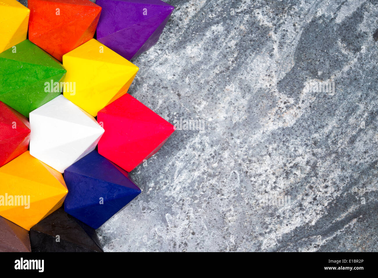 Bunte Rauten Wachsmalstifte in den Farben des Spektrums oder Regenbogen angeordnet in einer engen Gruppe als einen linken Rand auf Stockfoto