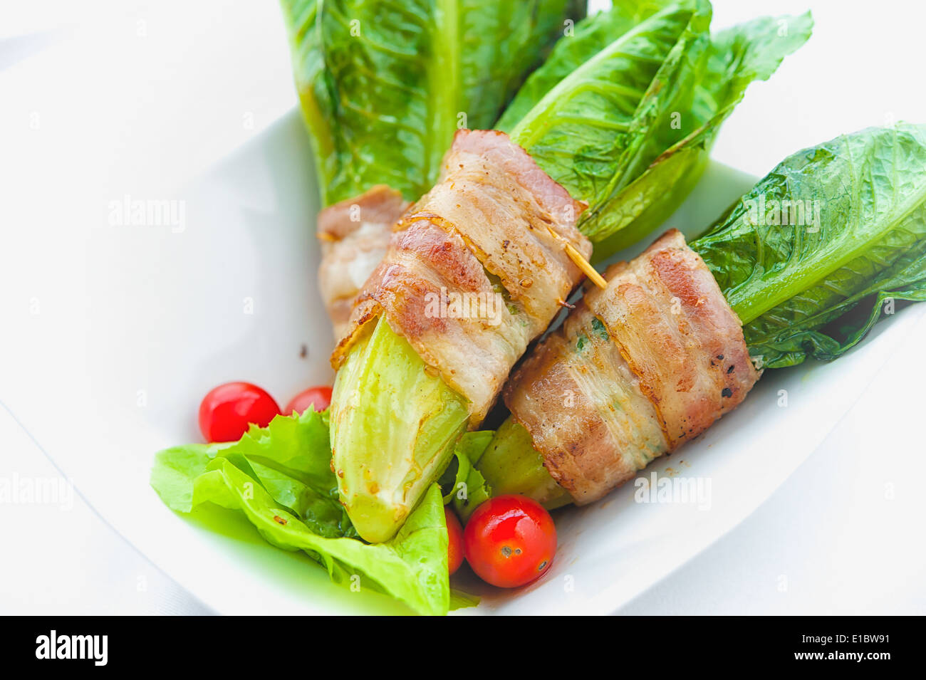 grüne cos eingewickelt in Speck auf weiße Schale Stockfoto