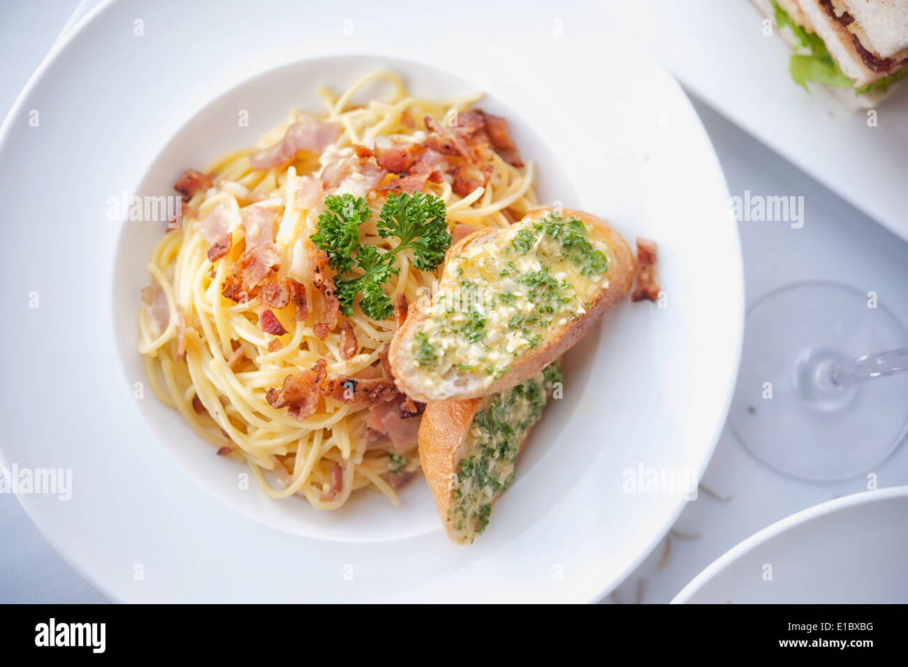 Spaghetti mit Speck und Knoblauch Brot auf weiße Schale Stockfoto