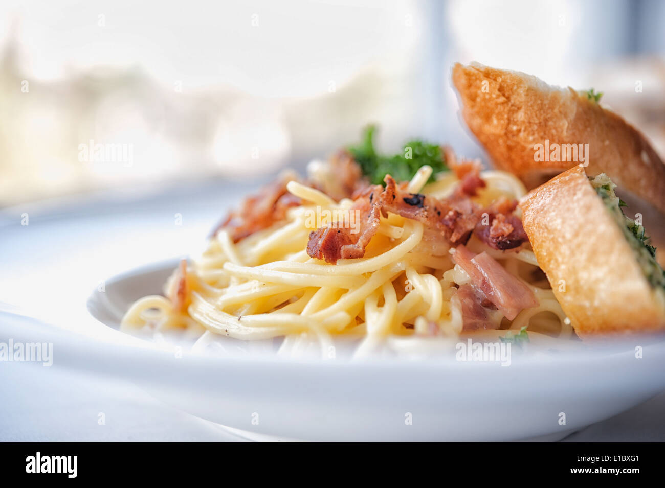 Spaghetti mit Speck und Knoblauch Brot auf weiße Schale Stockfoto