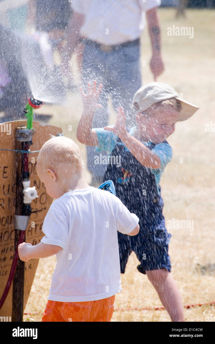 Tewkesbury Mittelalterfest, Gloucester UK Juli 2013: Kinder spielen im Wasser Abkühlung sprühen an einem sehr warmen sonnigen Tag an der th Stockfoto