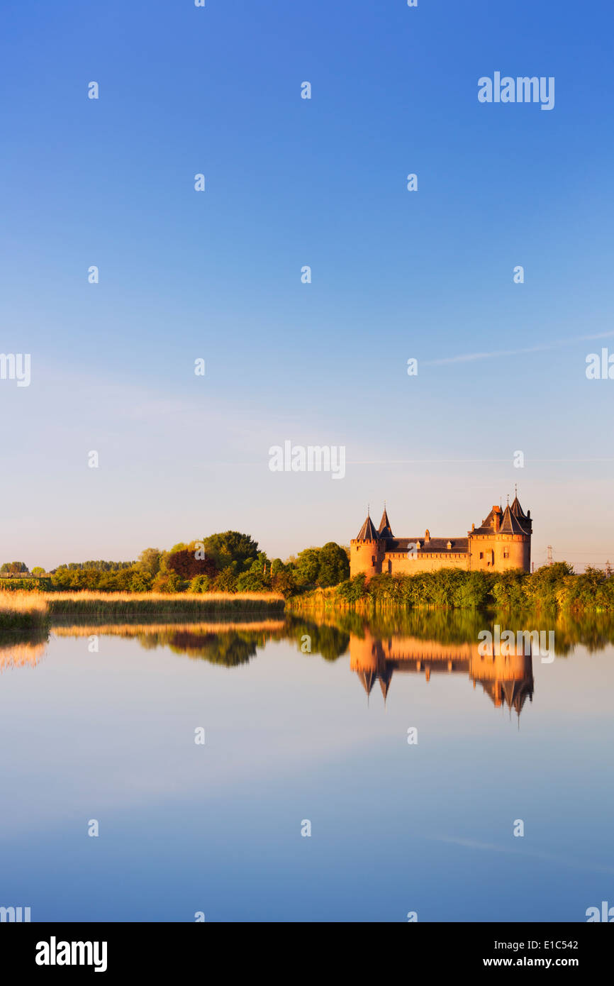 Eine mittelalterliche Burg spiegelt sich in einem See bei Sonnenaufgang Stockfoto
