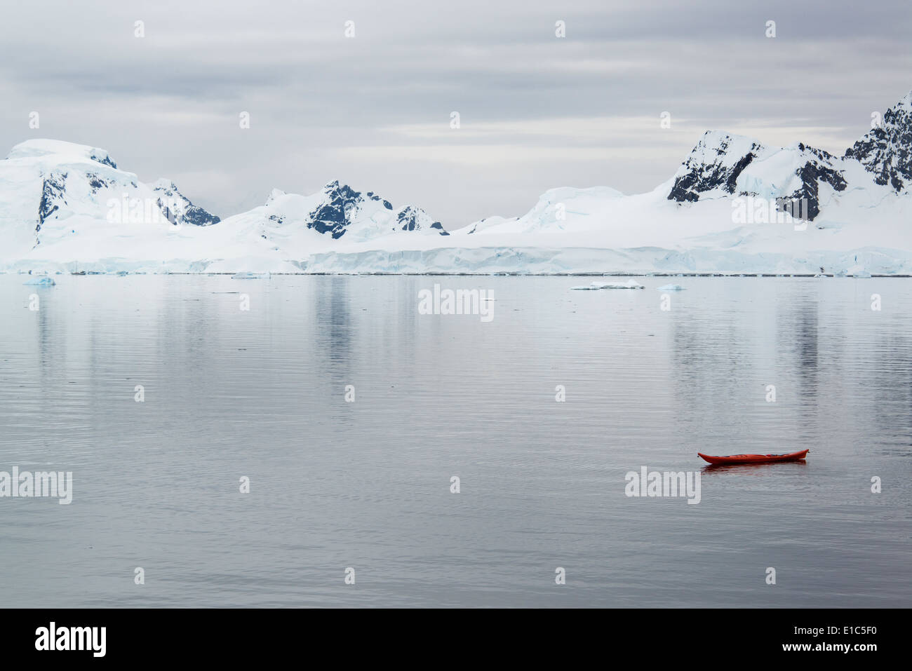 Ein kleines Boot, Kajak auf den flachen ruhigen Gewässern vor der Küste eines antarktischen Insel. Stockfoto
