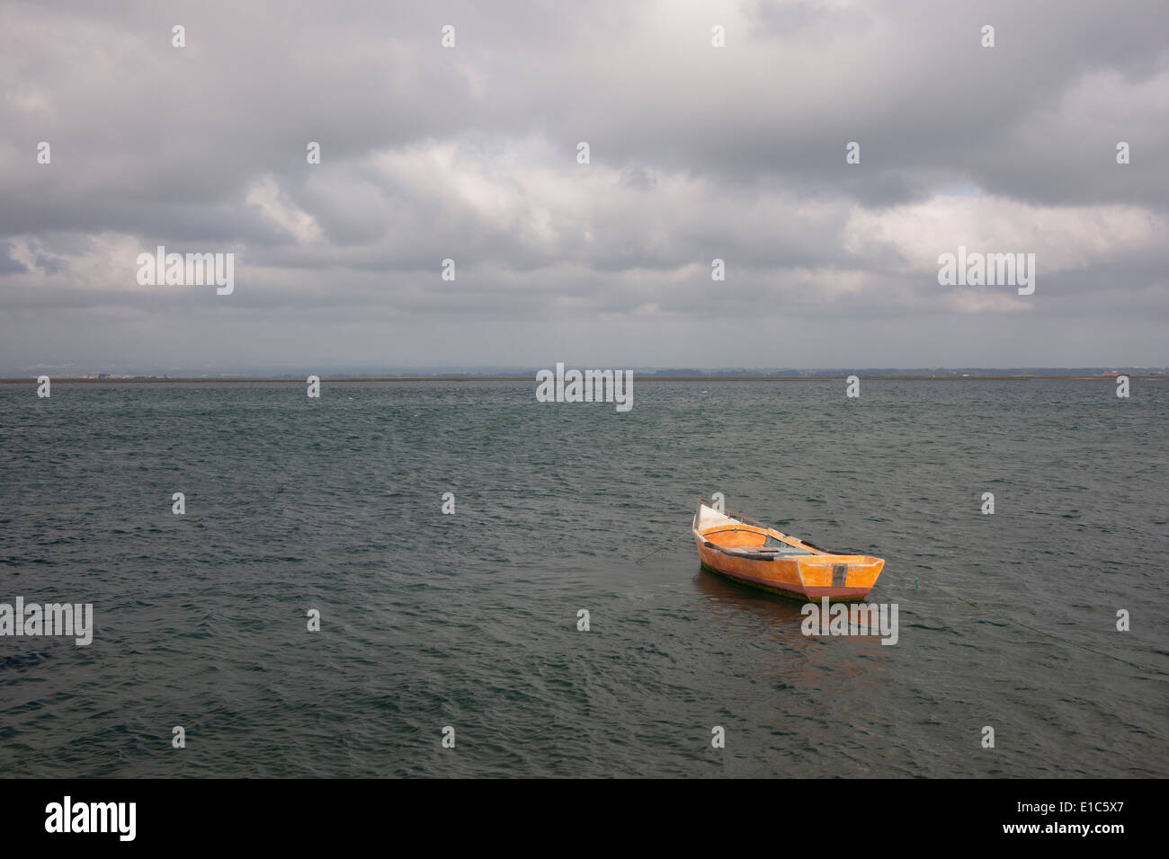 Ein kleines hölzernes Boot vertäut im Freiwasser vor der portugiesischen Küste. Stockfoto