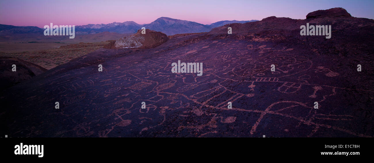 Sky Rock Petroglyphen in der Nähe von Bishop, Kalifornien, während des Sonnenuntergangs mit der Sierra Nevada Bergkette in der Ferne. Stockfoto