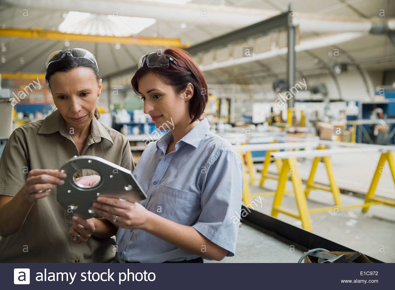 Arbeitnehmer, die Prüfung Metallteil im Werksgelände Stockfoto