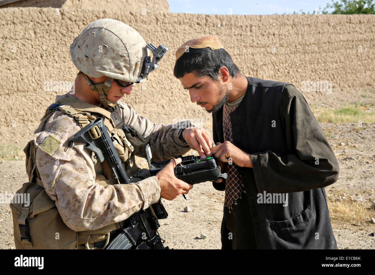 Ein US-Marine mit dem 1. Bataillon, 7. Marineregiment verwendet eine biometrische Anmeldung und Screening-Gerät auf einen Dorfbewohner während einer Mission zur Niederschlagung von Aufständen 15. Mai 2014 in Larr Dorf, Provinz Helmand, Afghanistan. Stockfoto