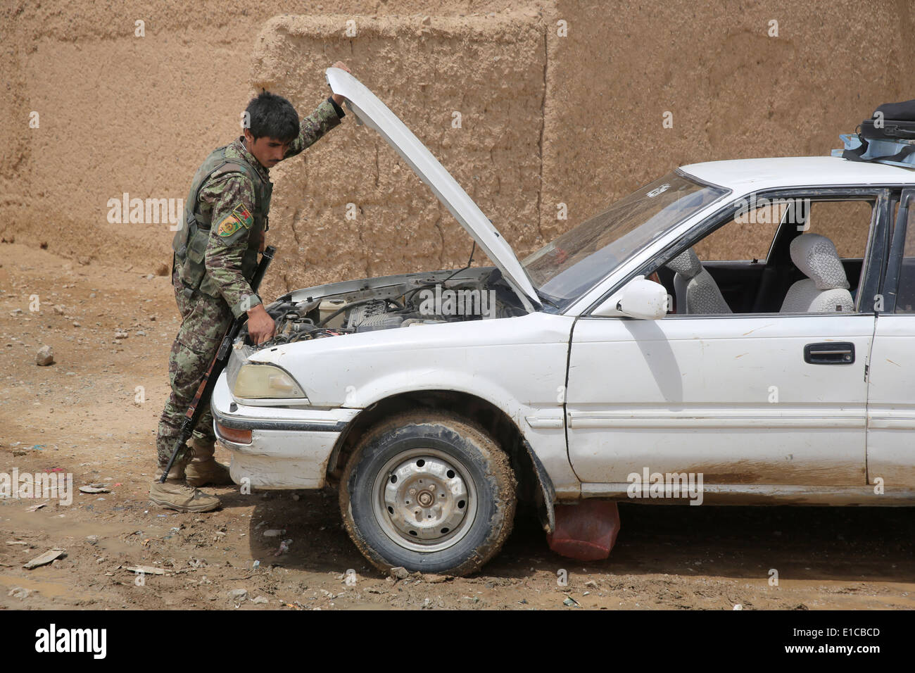 Ein Afghan National Army Soldat prüft ein Auto für Sprengstoff während einer gemeinsamen Patrouille mit US-Marines im 16. Mai 2014 in Larr Dorf, Provinz Helmand, Afghanistan. Stockfoto